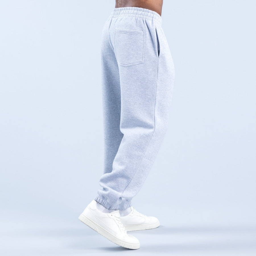 Light blue graphic joggers, side view, elastic waist and ribbed ankle cuffs, with white sneakers