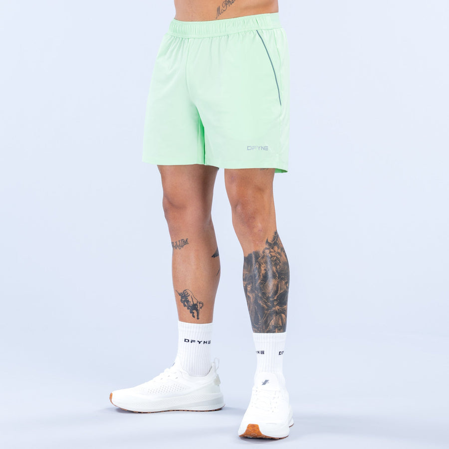 Light green training shorts with elastic waistband and 6-inch inseam, side logo