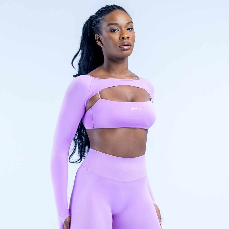 Lavender long-sleeve shrug over sports bra with wide neckline and fitted torso