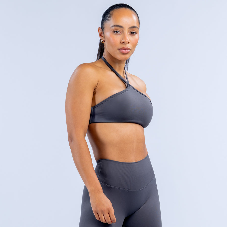 Dark gray high-neck halter sports bra with smooth front and thin crossover straps