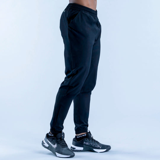 Dark training jogger pants back view, elastic waistband and tapered legs