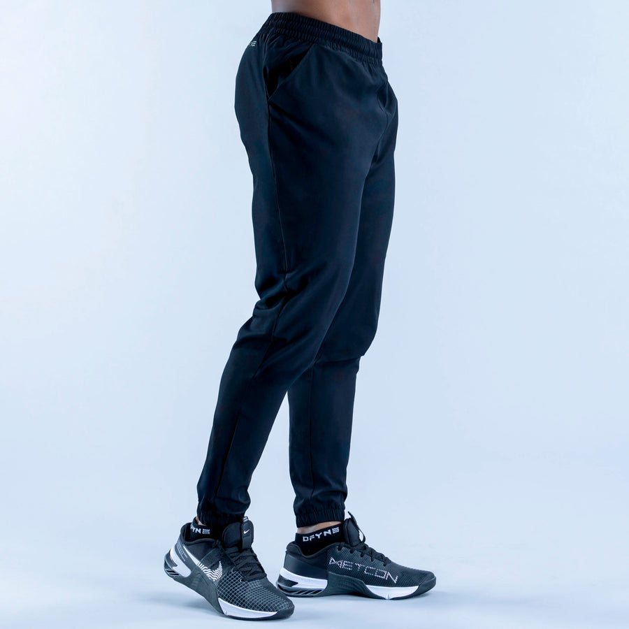 Dark training jogger pants back view, elastic waistband and tapered legs