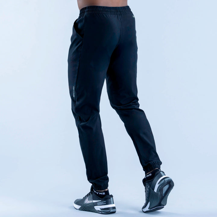 Dark training jogger pants from side view, elastic waistband and tapered fit