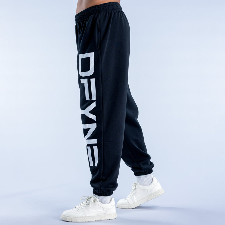 Dark cuffed jogger pants with large white vertical logo print on thigh
