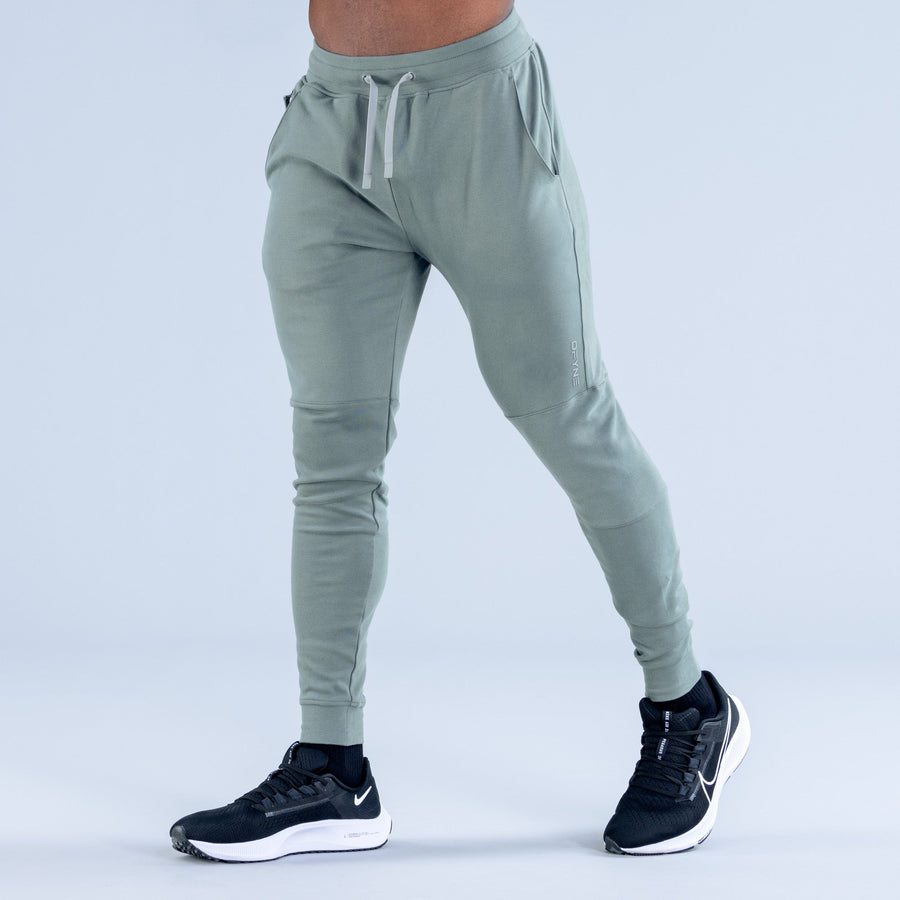 Sage green tapered jogger pants with drawstring waistband and cuffed ankle hems