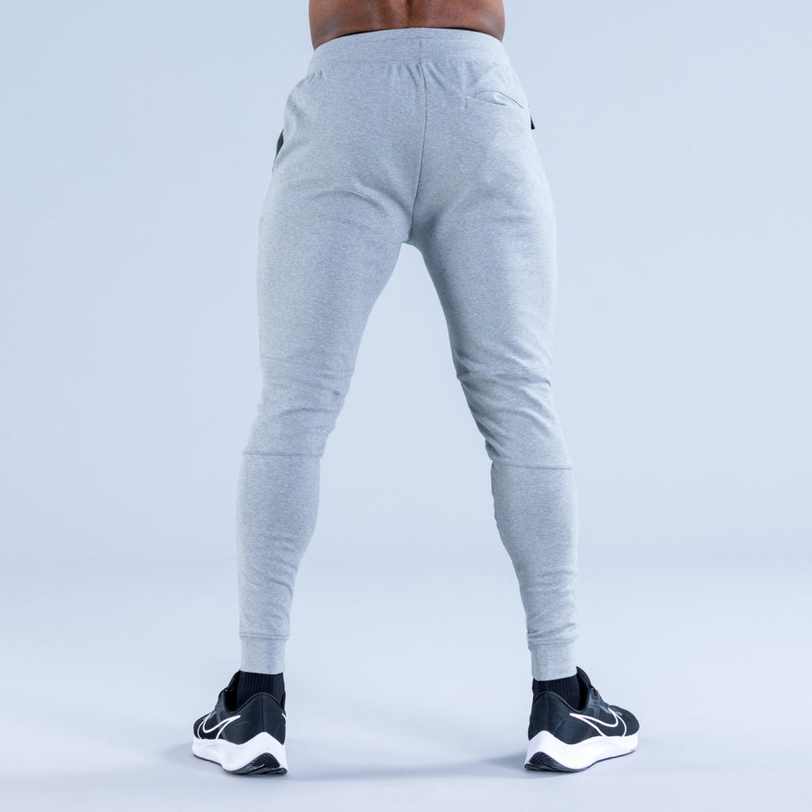 Light gray tapered jogger pants, rear view, with drawstring and cuffed hem