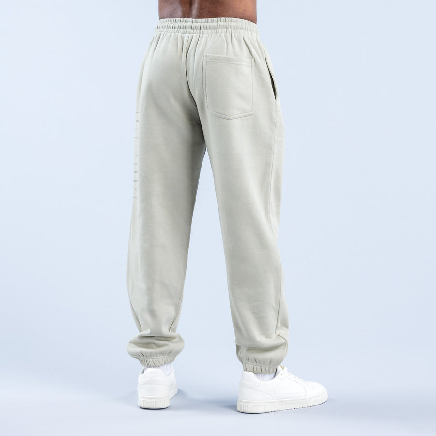 Cream joggers with elastic waistband, back pocket, and ribbed ankle cuffs
