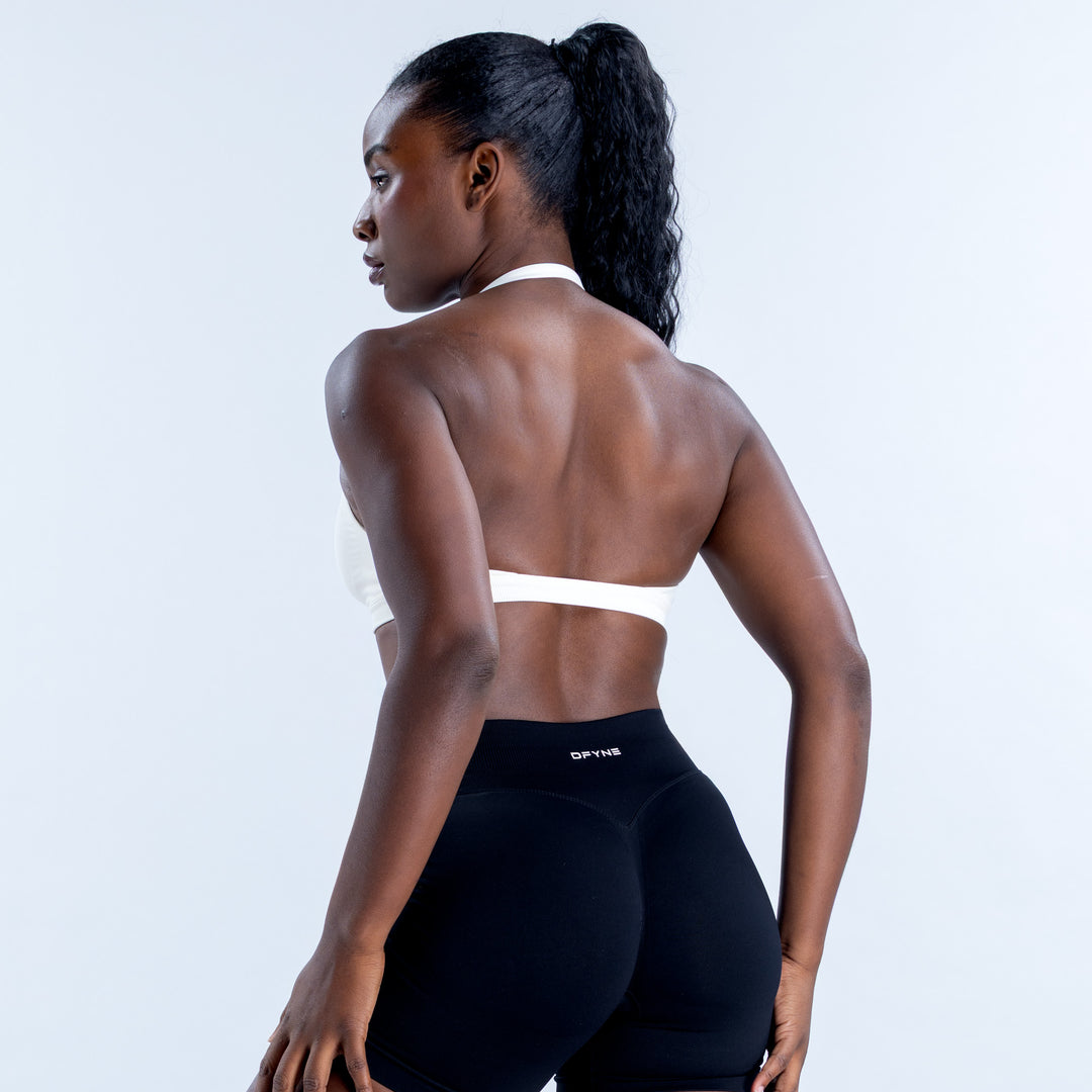 White Impact Sports Bra with a narrow back band and halter straps, rear view
