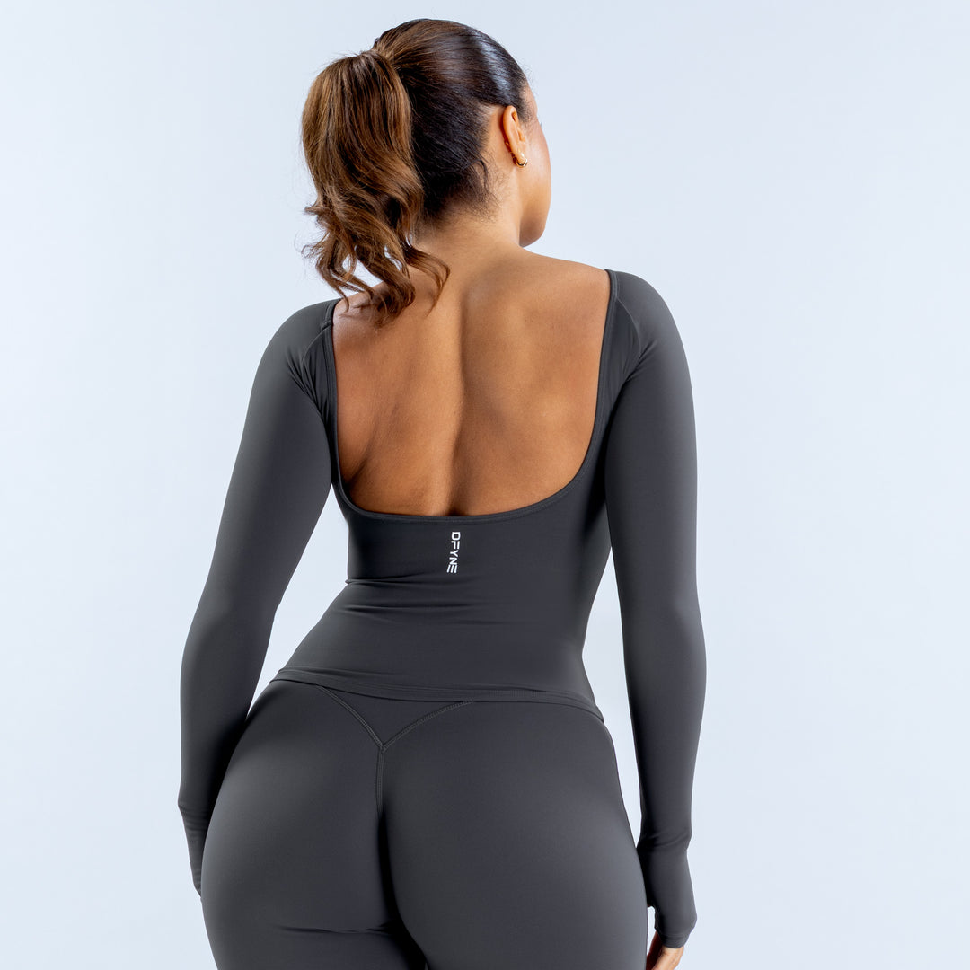 Back of charcoal long sleeve top with a deep square scoop and small logo