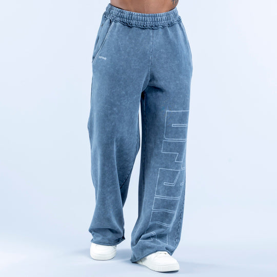 Washed jogger pants in blue wash with elastic waistband and large vertical line-art graphic