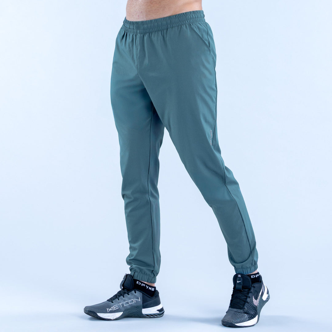 Teal training jogger pants with elastic waistband and tapered ankle cuffs