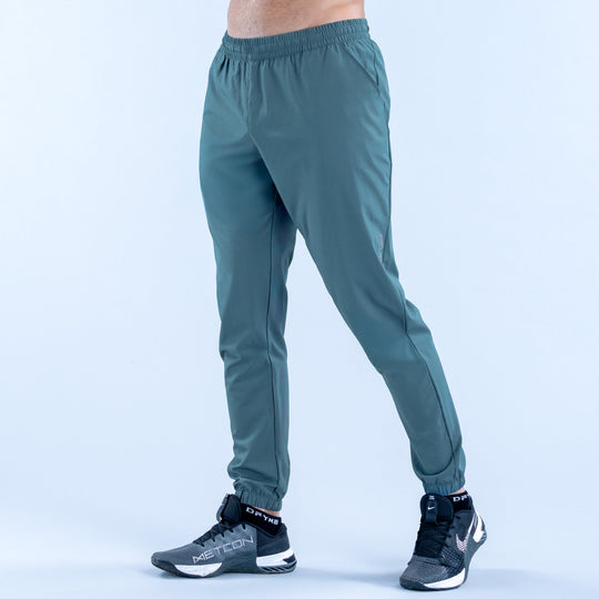 Teal training jogger pants with elastic waistband and tapered ankle cuffs