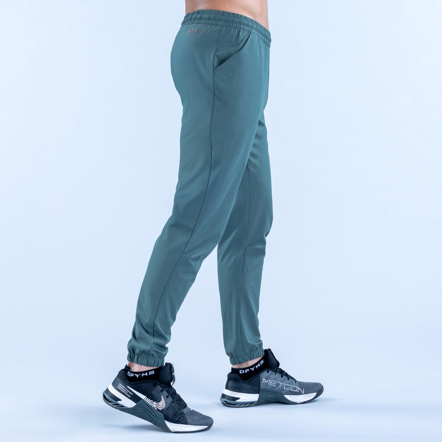 Teal training jogger pants, side view, elastic waistband and cuffed hems